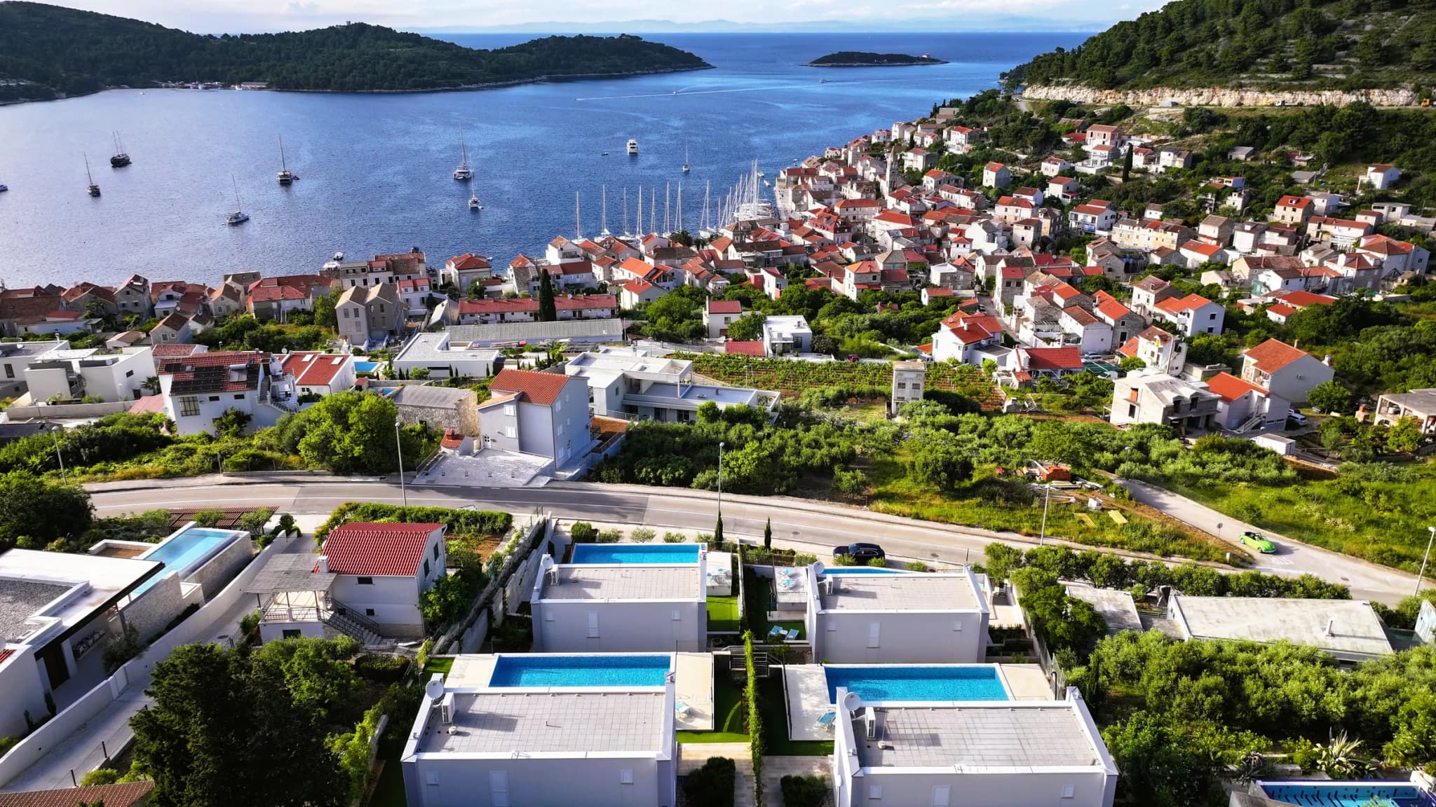 Četiri Ville Blue Villas iz zraka, s bazenima, gradom Visom i uvalom u pozadini